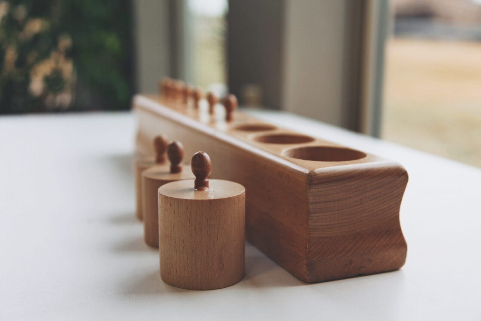 A wooden toy with four cups on top of it.