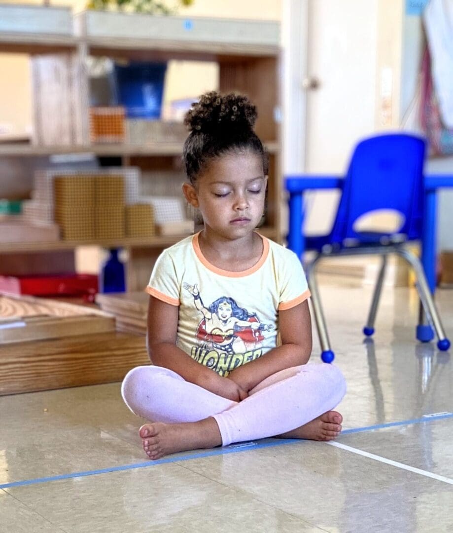 A little girl sitting on the floor in a room.