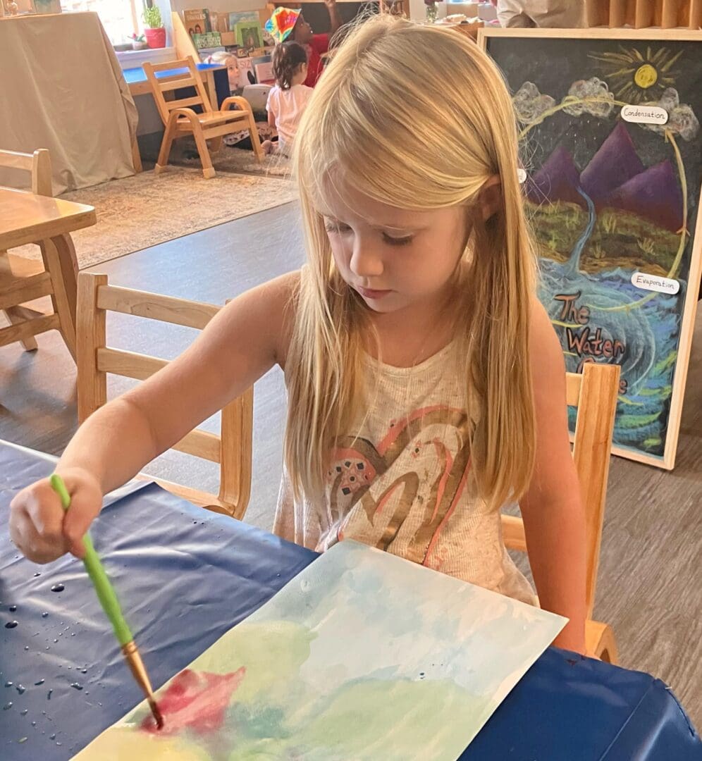 A little girl is painting with her brush.