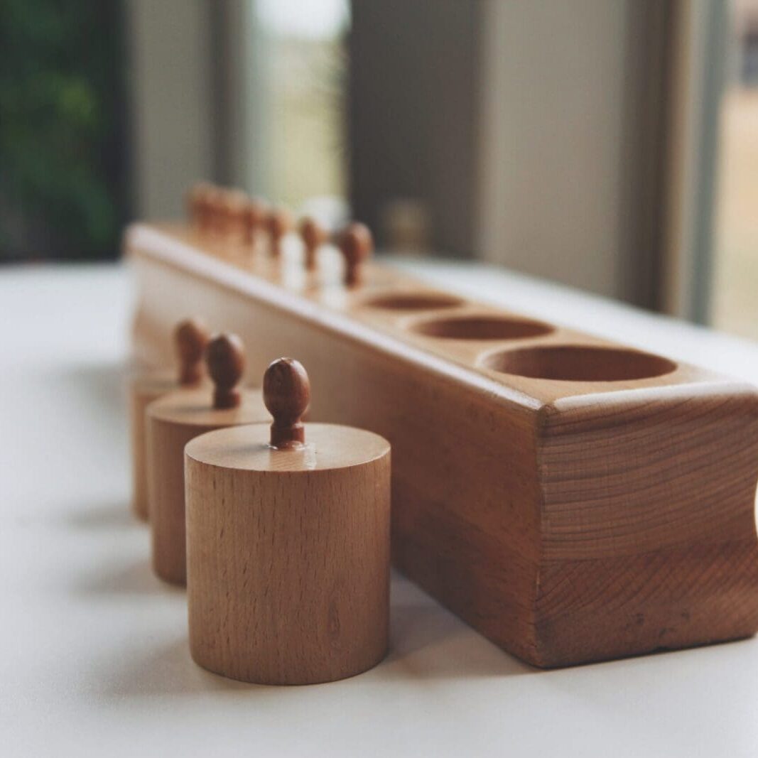 A wooden toy with four cups on top of it.